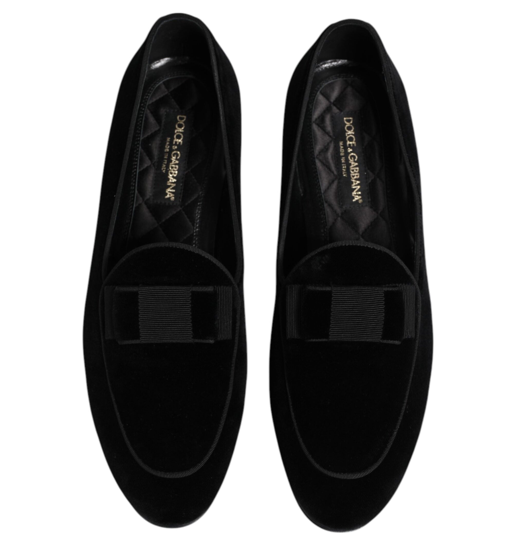 Black loafers with bow details on a white background