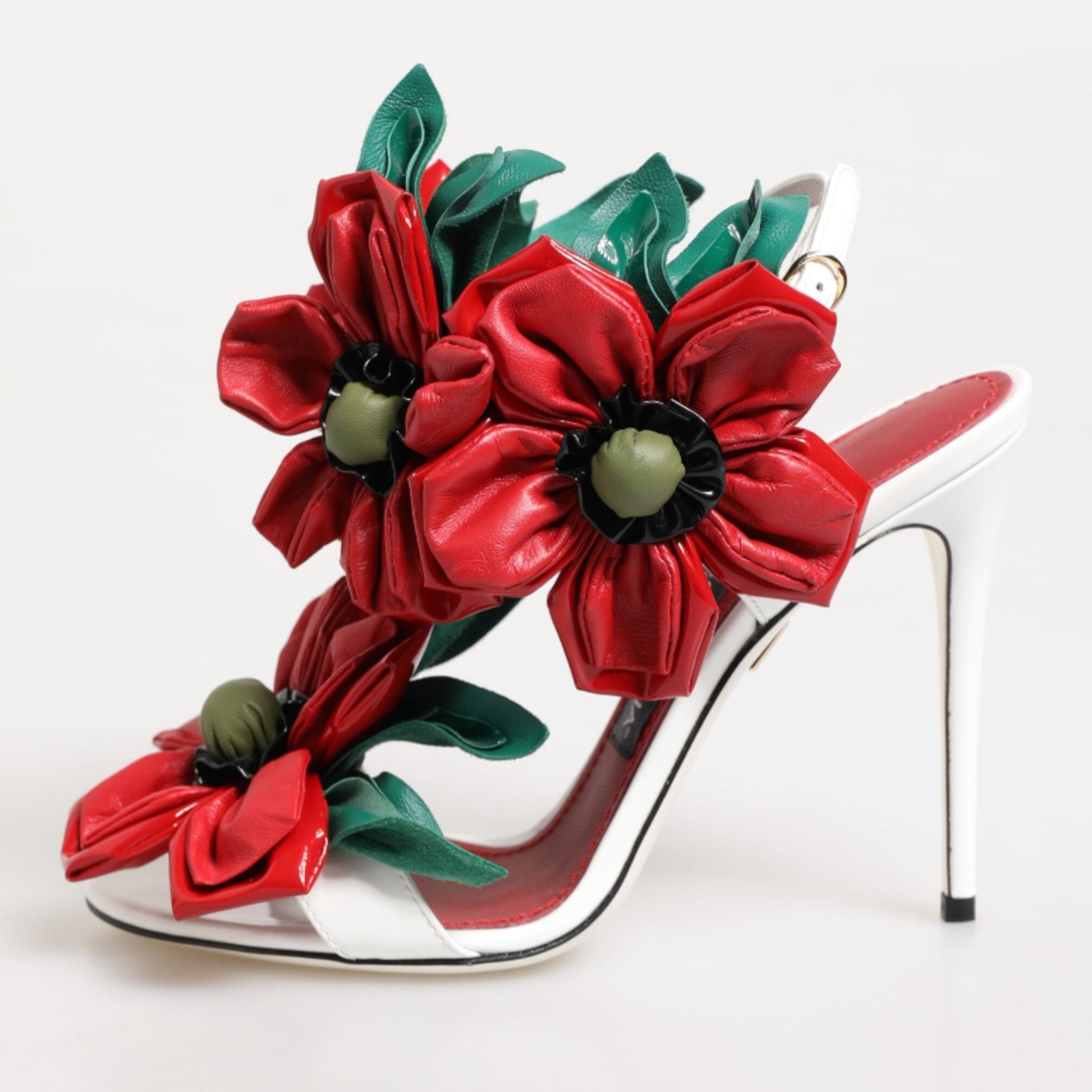 High-heeled shoe with red floral design on a white background