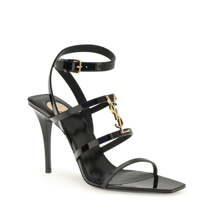 Black high-heeled sandal with gold accents on a white background
