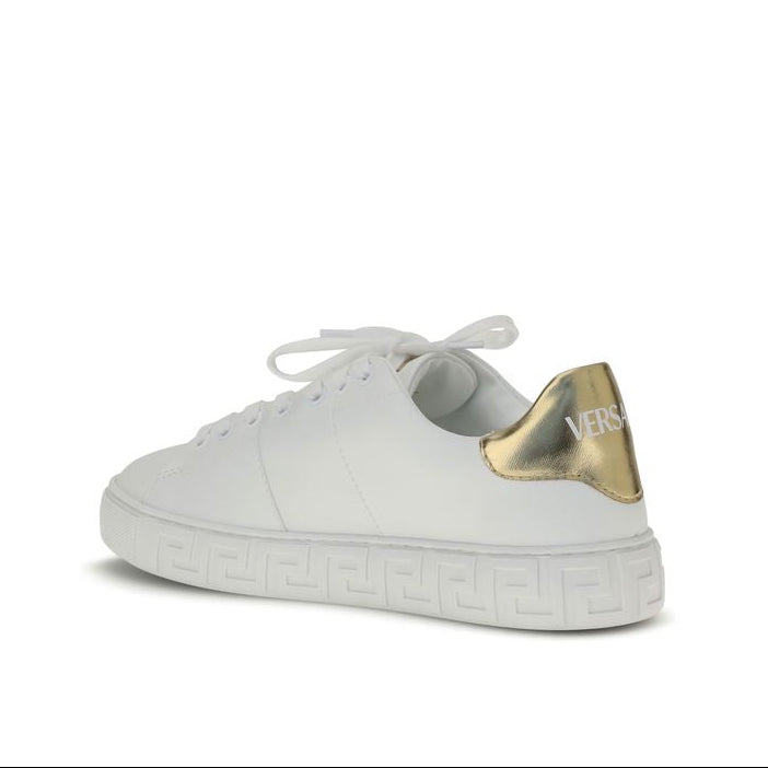 White sneaker with gold heel tab on a white background