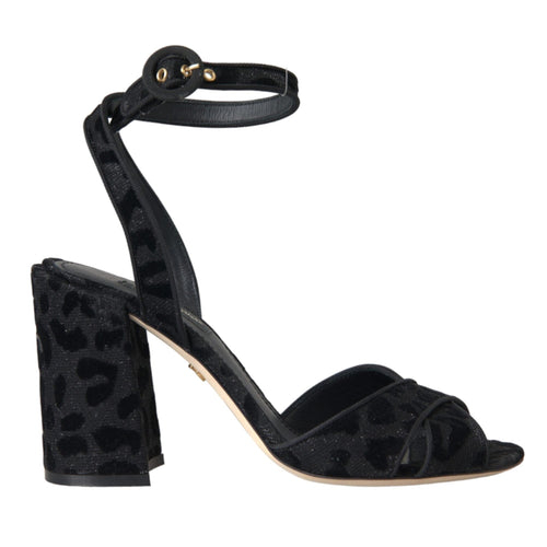 A pair of black leopard print suede ankle strap heels sandals with a leather buckle closure.