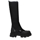 Black knee-high boot with a platform sole on a white background