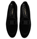Black loafers with bow details on a white background