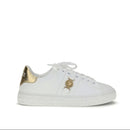 White sneaker with gold accents on a white background