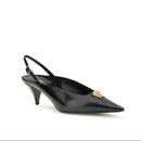 Black high-heeled shoe with a decorative gold emblem on a white background